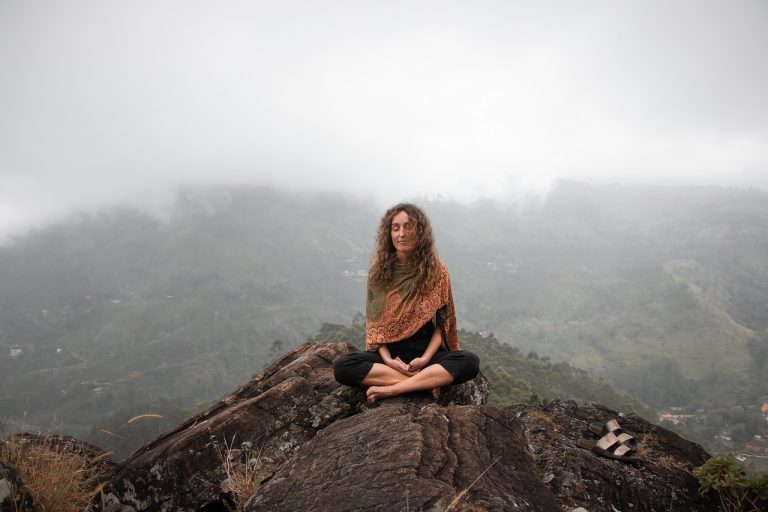 mujer meditando en la montaña